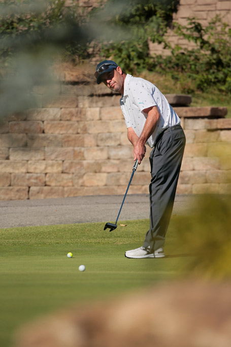 A man putting on the green at the BCI 2024 Jim Lang Memorial golf tournament